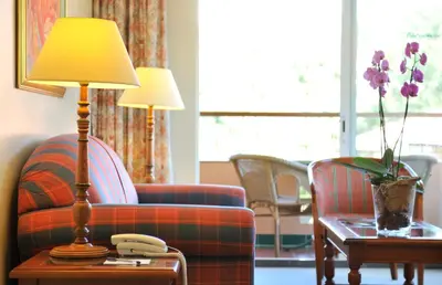 a living room with a couch and a lamp on a table at Pestana Miramar Garden & Ocean Hotel in Funchal