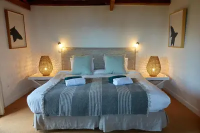 a bedroom with a large bed with two lamps at Quinta das Vinhas in Calheta