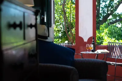 a table with a glass of wine on a patio at Quinta das Vinhas in Calheta
