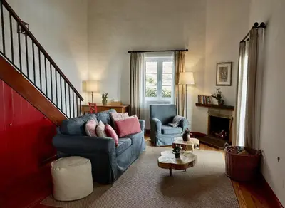 a living room with a blue couch and two chairs at Quinta das Vinhas in Calheta