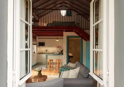 a living room with a couch and a kitchen at Quinta das Vinhas in Calheta