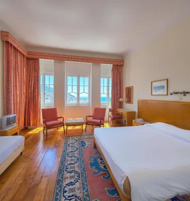 a hotel room with a bed and two chairs at Hotel Monte Carlo in Funchal