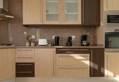 a kitchen with wooden cabinets and stainless steel appliances at Arco da Calheta Villa in Arco da Calheta