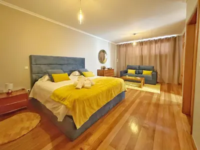 a bedroom with a large bed with a yellow blanket at Arco da Calheta Villa in Arco da Calheta