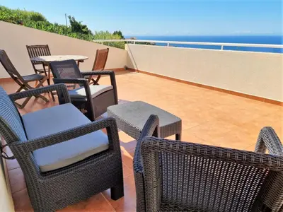 a patio with chairs and tables on a balcony at Arco da Calheta Villa in Arco da Calheta