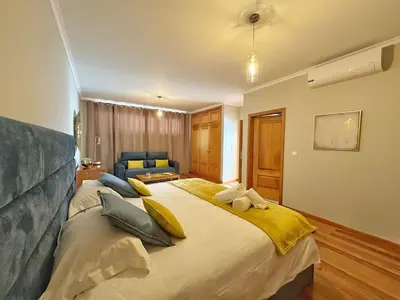 a bedroom with a large bed with yellow pillows at Arco da Calheta Villa in Arco da Calheta