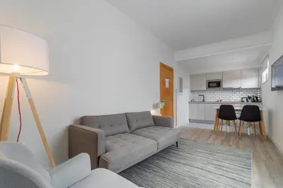 a living room with a couch and a kitchen at Aqua Natura Bay in Porto Moniz