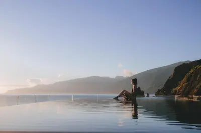 a woman sitting in a body of water at Aqua Natura Bay in Porto Moniz