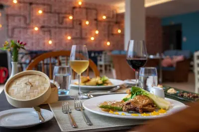 a table with a plate of food and glasses of wine at Aqua Natura Bay in Porto Moniz