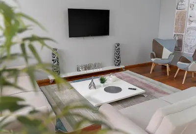 a living room with a couch and a tv on a wall at Charming Villa in Funchal in Funchal