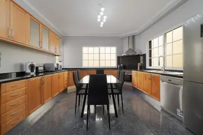 a kitchen with wooden cabinets and a table and chairs at Charming Villa in Funchal in Funchal