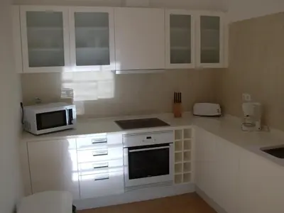 a kitchen with white cabinets and a microwave at Belver Porto Dona Maria Resort in Luz