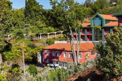 a house on the side of a hill with trees at Quinta do Monte in Funchal