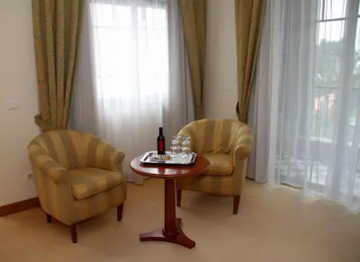 a room with two chairs and a table with a bottle of wine at Quinta do Monte in Funchal