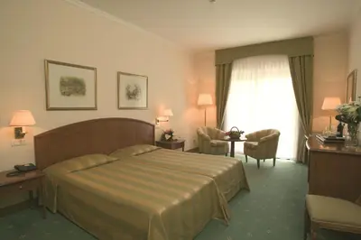 a hotel room with a bed and a chair and a window at Quinta do Monte in Funchal