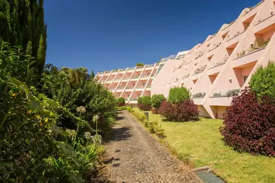an apartment building with a garden in front of it at Quinta do Estreito in Estreito de Câmara de Lobos