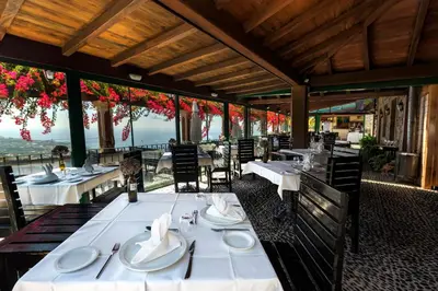 a restaurant with white tables and chairs with a view at Quinta do Estreito in Estreito de Câmara de Lobos