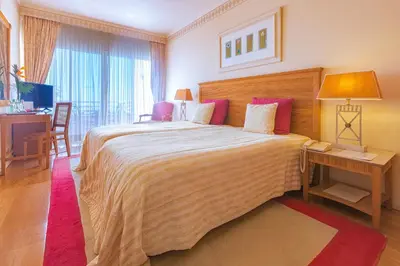 a bedroom with a large bed with a table and a desk at Quinta do Estreito in Estreito de Câmara de Lobos