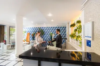 a man and a woman standing in a lobby at Terrace Mar Suite Hotel in Funchal