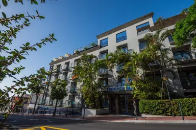 a building with palm trees in front of it at Terrace Mar Suite Hotel in Funchal