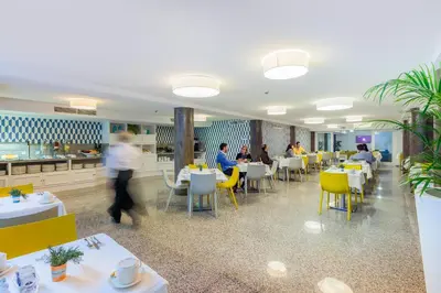a dining room with people sitting at tables at Terrace Mar Suite Hotel in Funchal