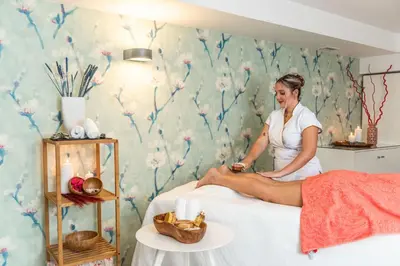 a woman sitting on a bed in a bedroom at Terrace Mar Suite Hotel in Funchal