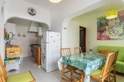 a kitchen and dining room with a table and a refrigerator at Geo House in Vila do Bispo