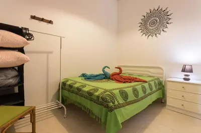 a childs bedroom with a bed with a green blanket at Geo House in Vila do Bispo