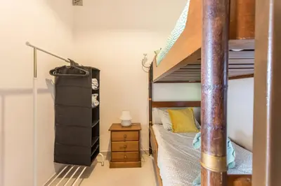 a bedroom with a bunk bed with a wooden bed frame at Geo House in Vila do Bispo