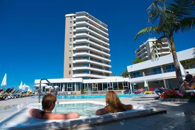 two women sitting in the pool at a resort at Duas Torres Hotel in Funchal