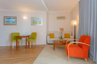 a living room with a couch and a table and chairs at Duas Torres Hotel in Funchal