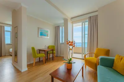 a living room with a couch and chairs and a table at Duas Torres Hotel in Funchal