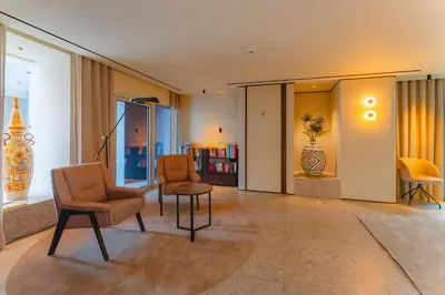 a living room with chairs and a table and a book shelf at Duas Torres Hotel in Funchal
