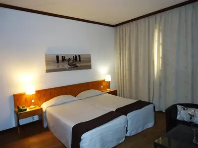 a hotel room with a large bed and a window at Hotel Windsor in Funchal
