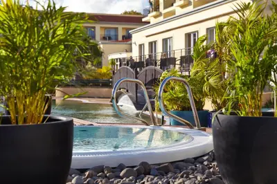 a hot tub in a yard with potted plants at PortoBay Santa Maria - Adults Only in Funchal
