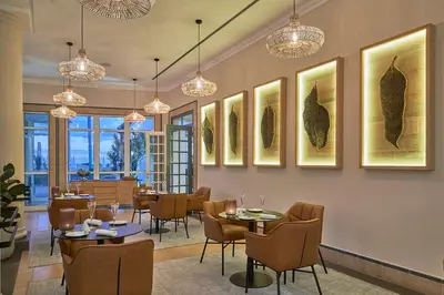 a restaurant with tables and chairs and paintings on the wall at PortoBay Santa Maria - Adults Only in Funchal