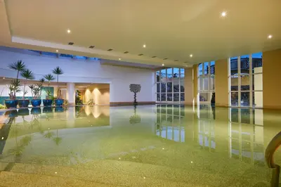 an empty lobby with a pool in a building at PortoBay Santa Maria - Adults Only in Funchal