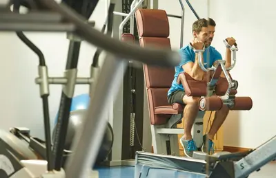 a man is sitting on a gym bench at PortoBay Santa Maria - Adults Only in Funchal