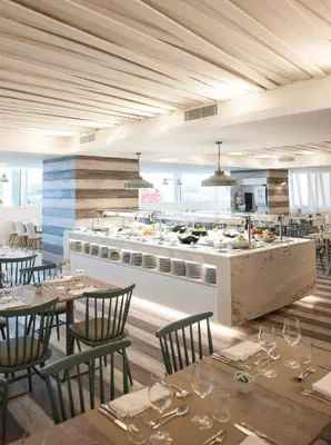 a restaurant with tables and chairs and a kitchen at Hotel Alto Lido in Funchal