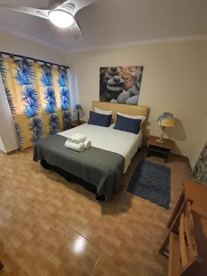 a bedroom with a large bed with blue pillows at Ocean View Lagos in Lagos