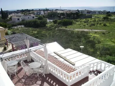 a balcony of a house with a table and chairs at Ocean View Lagos in Lagos
