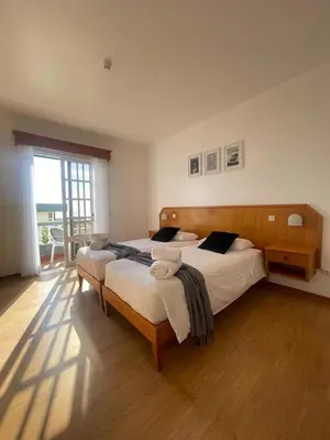 a bedroom with two beds and a large window at Valhalla Panorama in Funchal