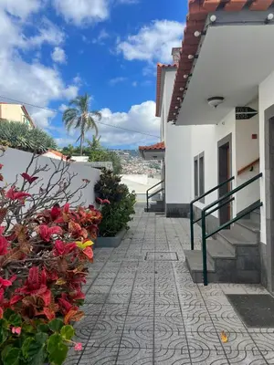 a walkway next to a white building with flowers at Valhalla Panorama in Funchal