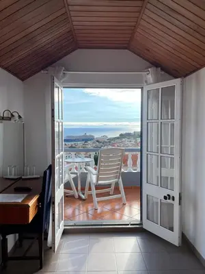 a room with a balcony with a table and a chair at Valhalla Panorama in Funchal