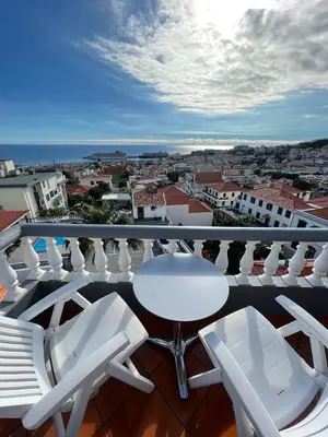 a balcony with white chairs and a table and a view at Valhalla Panorama in Funchal