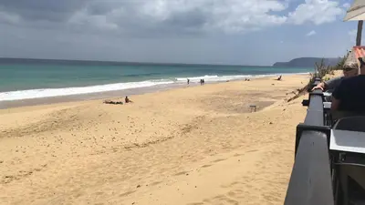 a view of a beach with people on the sand at casa de praia Nunes Village in Porto Santo