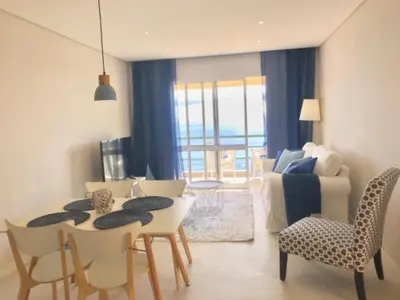 a living room with a couch and a table and chairs at Apartamento Reis Magos in Caniço