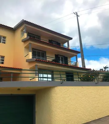 a large yellow building with a balcony on top of it at Apartamento Reis Magos in Caniço