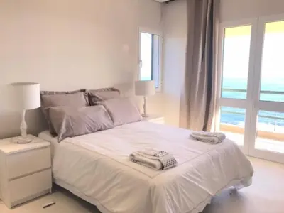 a white bedroom with a bed with towels on it at Apartamento Reis Magos in Caniço