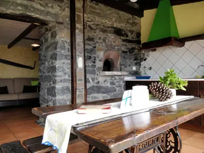 a table in a kitchen with a pizza oven at Calhau Grande in Arco da Calheta